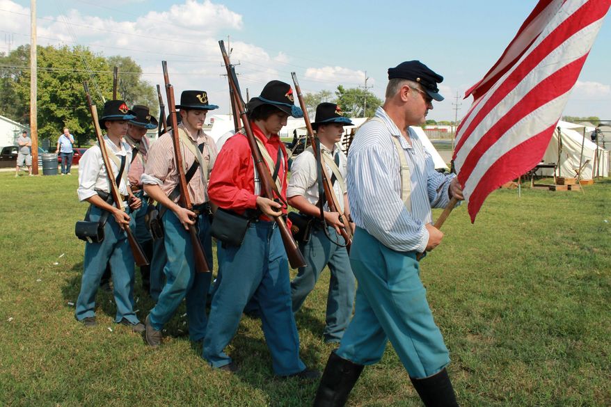 In this Sept. 24, 2016 photo, Downs, Ill., based Civil War re-enactors of Company D, 21st Illinois Infantry Regiment, march during a drill demonstration as a part of Grant Days in Mattoon, Ill. Their re-enactments vary in size and scope. There can be about seven to 10 guys portraying an encampment, or, there can be a group of over 18 representing a unit in a battle re-enactment. at the Civil War Memorial Ellipse and Camp Grant Municipal Park. (Jarad Jarmon/Journal Gazette via AP)