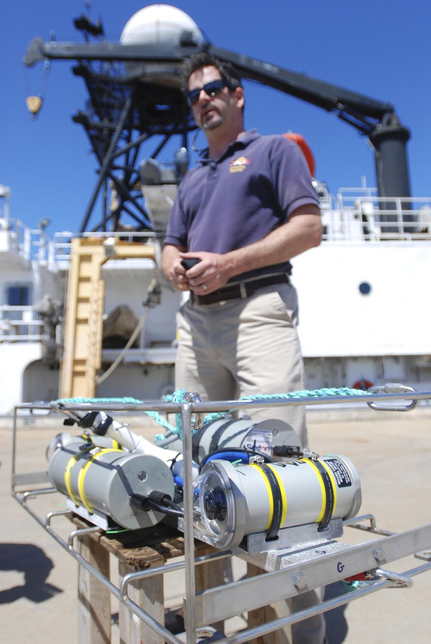 National Ocean and Atmospheric Administration biologist Benjamin Richards talks about an upcoming study of seven species of Hawaii’s deep-water bottom fish during a news conference on Ford Island near Honolulu, Tuesday, Oct. 11, 2016. The first-ever comprehensive survey will bring local commercial fishermen and scientists together to get a count of several species of grouper and snapper, which are popular table fare. NOAA has developed a camera system, foreground, to help capture the data. (AP Photo/Caleb Jones)