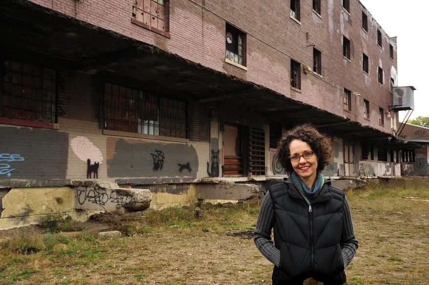 In a Oct. 16, 2013 photo, Tracy Sides, who won the "Forever St. Paul Challenge," a contest for the best idea to improve life in St. Paul, Minn. stands near an abandoned warehouse just east of downtown St. Paul, that was part of her winning proposal. Urban Oasis, a nonprofit that won $1 million to promote the growing and cooking of local food in St. Paul, is disbanding after three years. The St. Paul Foundation awarded the money to Urban Oasis in 2013 in a contest for ideas on how to improve life in the inner city. Urban Oasis founder Tracy Sides said the Urban Oasis business model was unsustainable and that it has spent all of the contest money. (Scott Takushi/St. Paul Pioneer Press via AP)