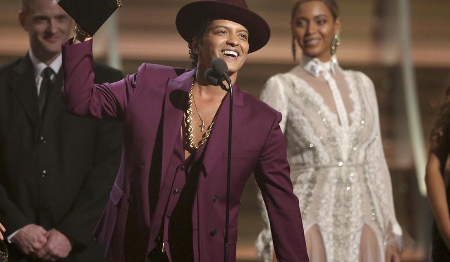FILE - In this Feb. 15, 2016 file photo, Bruno Mars accepts the award for record of the year for “Uptown Funk” at the 58th annual Grammy Awards in Los Angeles.  Mars, Justin Bieber and Britney Spears are set to perform during the 12-date “Jingle Ball” tour this holiday season. IHeartMedia announced Tuesday, Oct. 11, that the tour will kick off Nov. 29 in Dallas and wrap Dec. 18 in Miami. (Photo by Matt Sayles/Invision/AP, File)