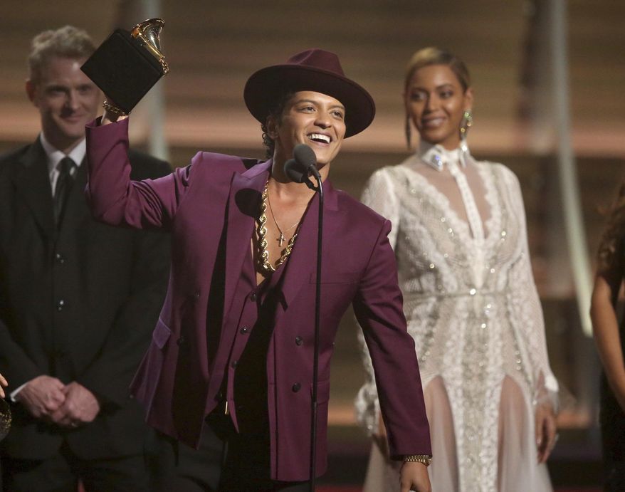 FILE - In this Feb. 15, 2016 file photo, Bruno Mars accepts the award for record of the year for “Uptown Funk” at the 58th annual Grammy Awards in Los Angeles. Mars, Justin Bieber and Britney Spears are set to perform during the 12-date “Jingle Ball” tour this holiday season. IHeartMedia announced Tuesday, Oct. 11, that the tour will kick off Nov. 29 in Dallas and wrap Dec. 18 in Miami. (Photo by Matt Sayles/Invision/AP, File)