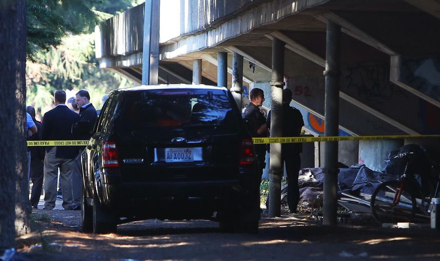 Police investigate the scene of an officer-involved shooting on Tuesday, Oct. 11, 2016, at Airport Way South and South Bayview Street, near the "Jungle" homeless encampment that was being cleared out to relocate its residents. (Genna Martin/seattlepi.com via AP)
