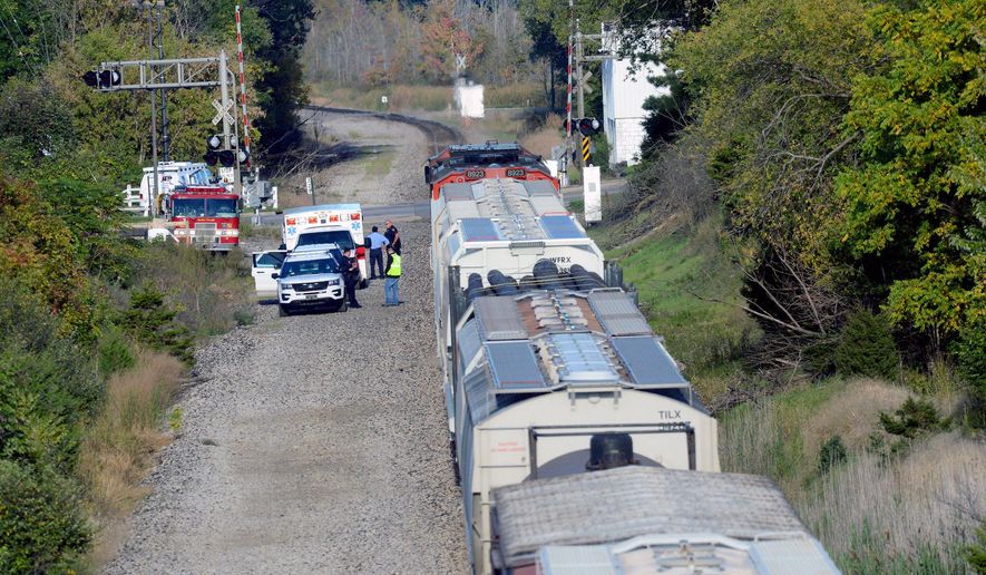 In this Monday, Oct. 10, 2016 photo, emergency crews investigate a fatal train crash near the intersection of Haslett and Marsh roads in Haslett, Mich. Authorities say a 13-year-old boy has died after being struck by a freight train in the Lansing area. (Dave Wasinger/Lansing State Journal via AP)