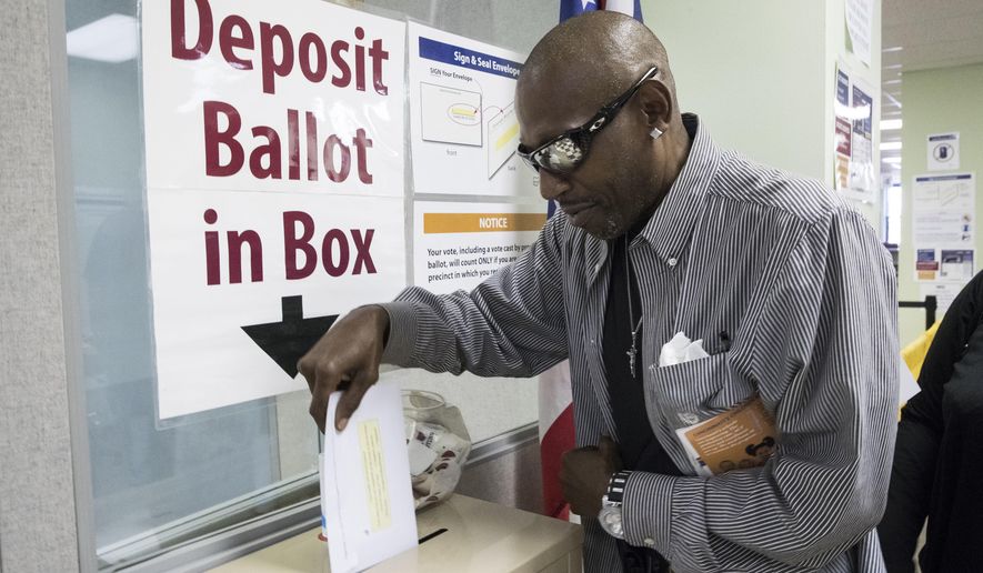 James Chambers deposits his vote into a ballot box at the Hamilton County Board of Elections as early voting begins statewide, Wednesday, Oct. 12, 2016, in Cincinnati. (AP Photo/John Minchillo)