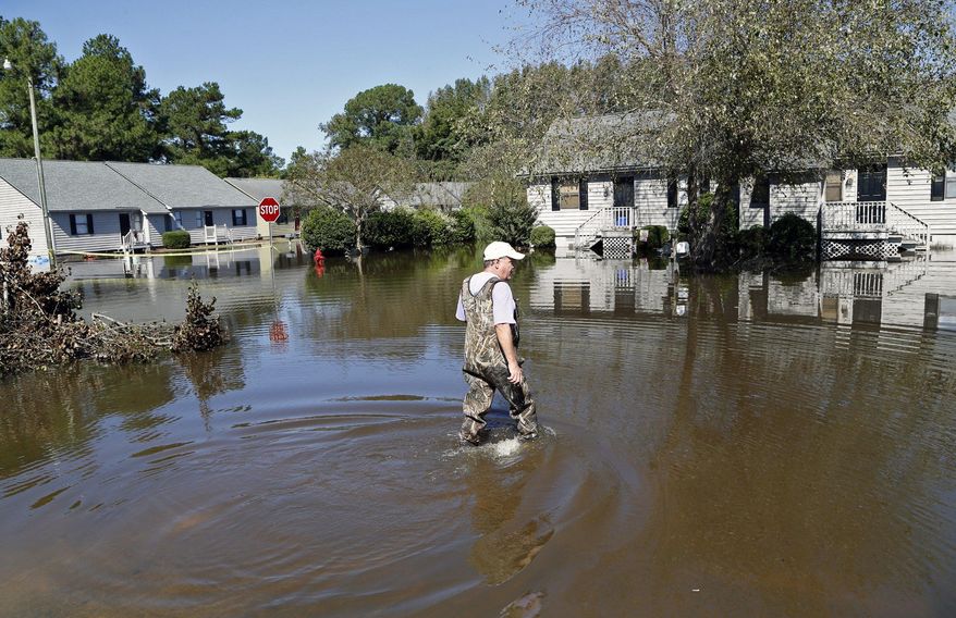 Mike Corey wears waders as he goes to check on his units as the floodwaters slowly rise at the Wyndham Circle duplex complex in Greenville, NC on Wednesday,Oct. 12, 2016. The homes were threatened as the Tar River came out of its banks from all the rains from Hurricane Matthew, which passed through the eastern part of the state a few days ago.  Some North Carolina rivers, like the Tar, continue to rise from the heavy rains, threatening property and forcing evacuations.  (Chris Seward/The News &amp;amp; Observer via AP)