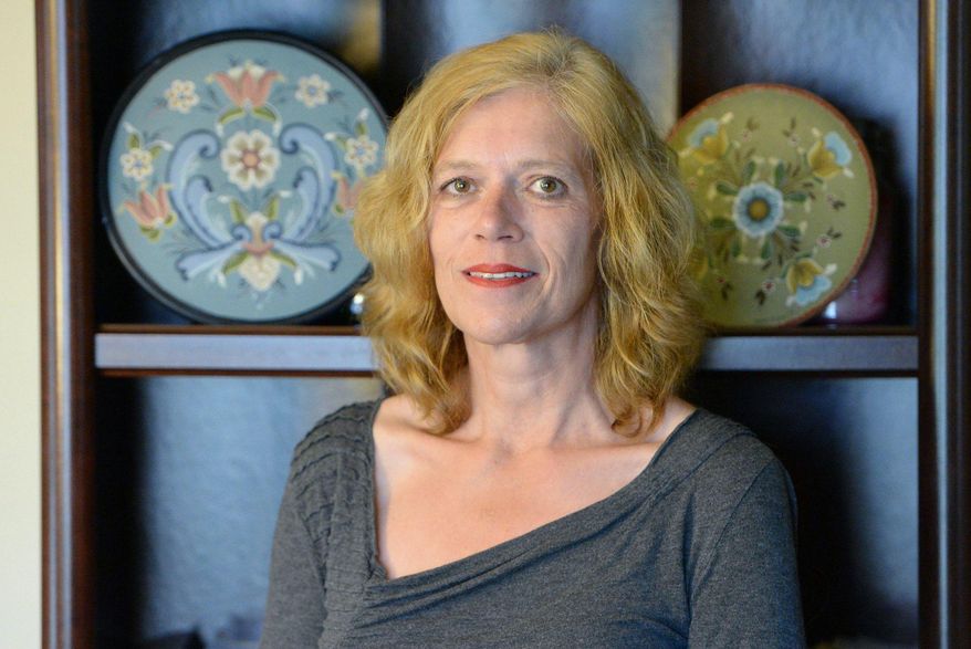 In this Sept. 17, 2016 photo, Shelley Kendall poses with two of her painted pieces in a Norwegian art style known as rosemaling at her Millcreek Township, Erie County, Pa., home. (Greg Wohlford /Erie Times-News via AP)