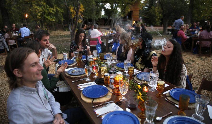 In this Oct. 2, 2016 photo, diners smoke marijuana as they eat dishes prepared by chefs during an evening of pairings of fine food and craft marijuana strains served to invited guests dining at Planet Bluegrass, an outdoor venue in Lyons, Colo. Chefs and pot growers trying to explore fine dining with weed face a legal gauntlet to make pot dinners a reality, even where the drug is legal. (AP Photo/Brennan Linsley)