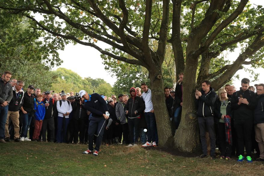 Sweden's Alex Noren is watched by onlookers as he plays out of the rough during day two of The British Masters golf tournament at The Grove in Chandler's Cross, England, Friday Oct. 14, 2016. (Adam Davy / PA via AP)