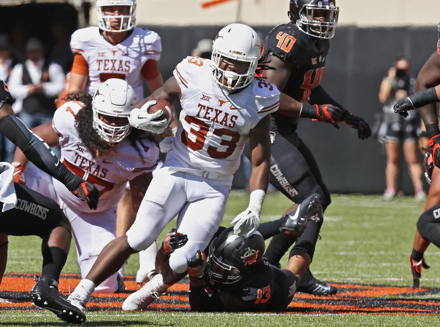 FILE - In this Oct. 1, 2016, file photo, Texas running back D'Onta Foreman (33) carries against Oklahoma State in the first half of an NCAA college football game, in Stillwater, Okla. While the Longhorns’ three-game losing skid keeps raising the pressure on coach Charlie Strong, Foreman keeps pounding away at opposing defenses and racking up some of the best rushing numbers in the country. Foreman’s 148.8 yards per game ranks second nationally and he’s averaging nearly seven yards per carry as Texas heads into a Saturday night matchup against Iowa State. (AP Photo/Sue Ogrocki, File)