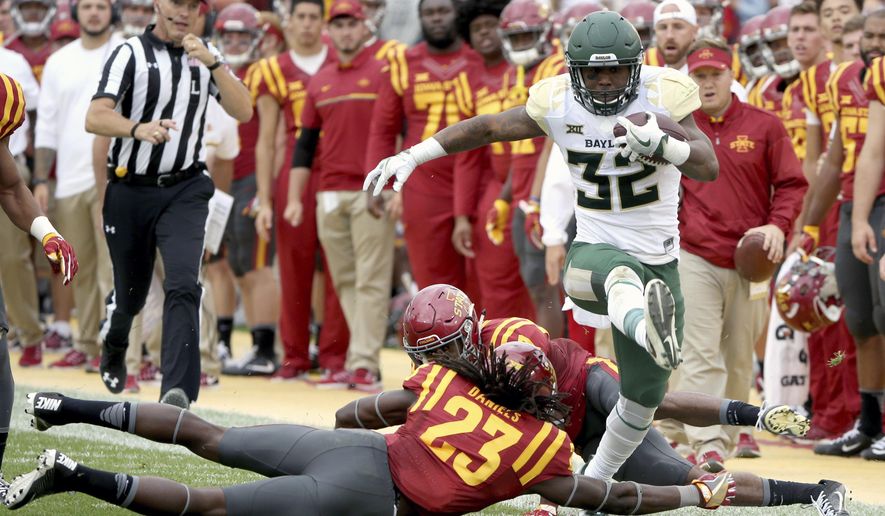FILE - In this Oct. 1, 2016, file photo, Baylor running back Shock Linwood high steps through Iowa State defensive back Thadd Daniels and Iowa State defensive back Jomal Wiltz during the first half of an NCAA college football game, in Ames, Iowa. Linwood became Baylor’s career rushing leader Sept. 16 at Rice. (AP Photo/Justin Hayworth, File)