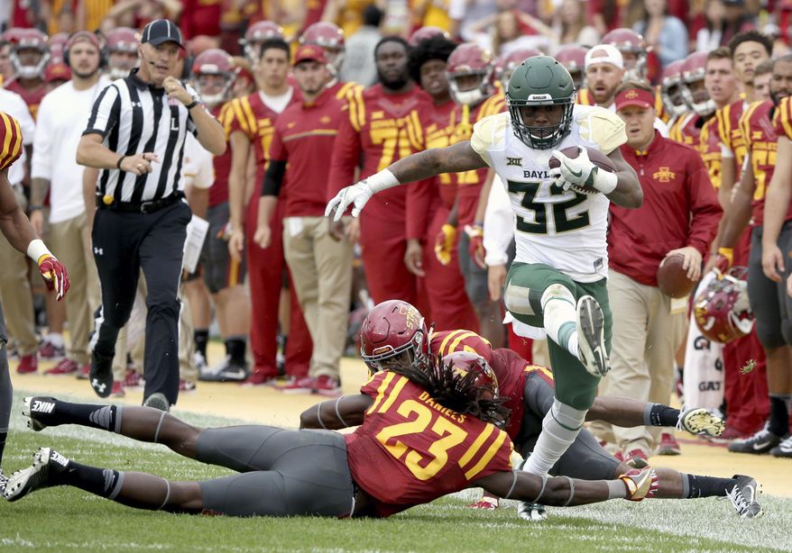 FILE - In this Oct. 1, 2016, file photo, Baylor running back Shock Linwood high steps through Iowa State defensive back Thadd Daniels and Iowa State defensive back Jomal Wiltz during the first half of an NCAA college football game, in Ames, Iowa. Linwood became Baylor’s career rushing leader Sept. 16 at Rice. (AP Photo/Justin Hayworth, File)