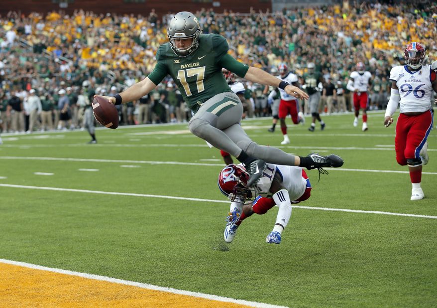 Baylor quarterback Seth Russell (17) leaps but is hit by Kansas linebacker Mike Lee (11) before entering the end zone for a touchdown after a short run in the first half of an NCAA college football game, Saturday, Oct. 15, 2016, in Waco, Texas. (AP Photo/Tony Gutierrez)