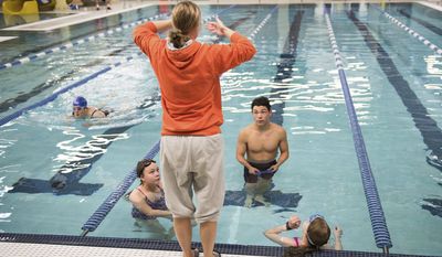 ADVANCE FOR WEEKEND EDITIONS, OCT. 15-16 - In this Sept. 22, 2016 photo, provided by Katie Basil, Bethel Regional High School swim coach Erika Andrews teaches swimming fundamentals to Kennedy Langlie, Alexie Leonard and Jordan Wheeler in Bethel, Alaska. Andrews is the first swim coach and is trying to build a swimming culture in Bethel, two years after the city's first pool opened. (Katie Basil/KYUK via AP)