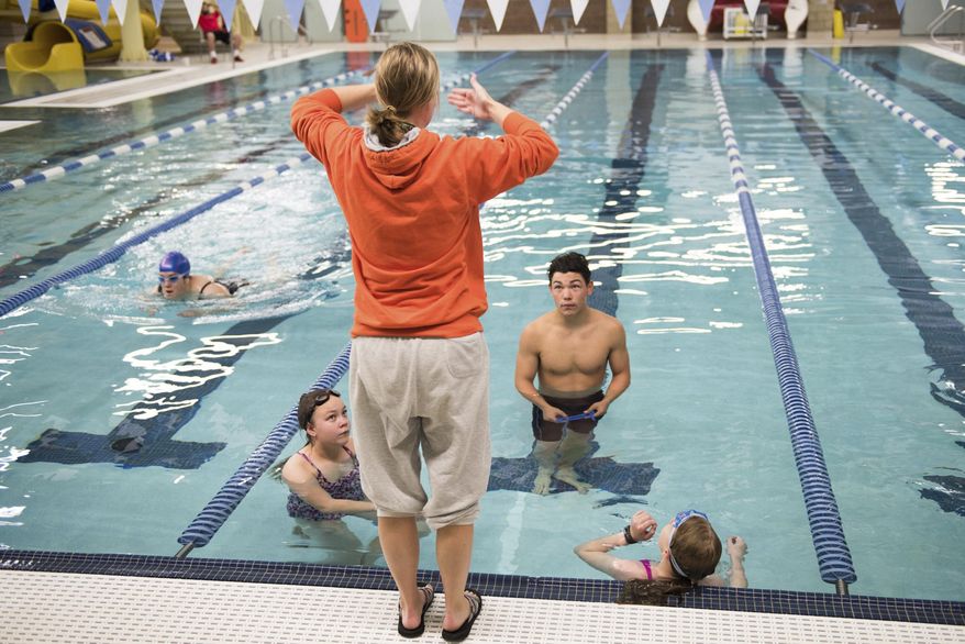 ADVANCE FOR WEEKEND EDITIONS, OCT. 15-16 - In this Sept. 22, 2016 photo, provided by Katie Basil, Bethel Regional High School swim coach Erika Andrews teaches swimming fundamentals to Kennedy Langlie, Alexie Leonard and Jordan Wheeler in Bethel, Alaska. Andrews is the first swim coach and is trying to build a swimming culture in Bethel, two years after the city's first pool opened. (Katie Basil/KYUK via AP)
