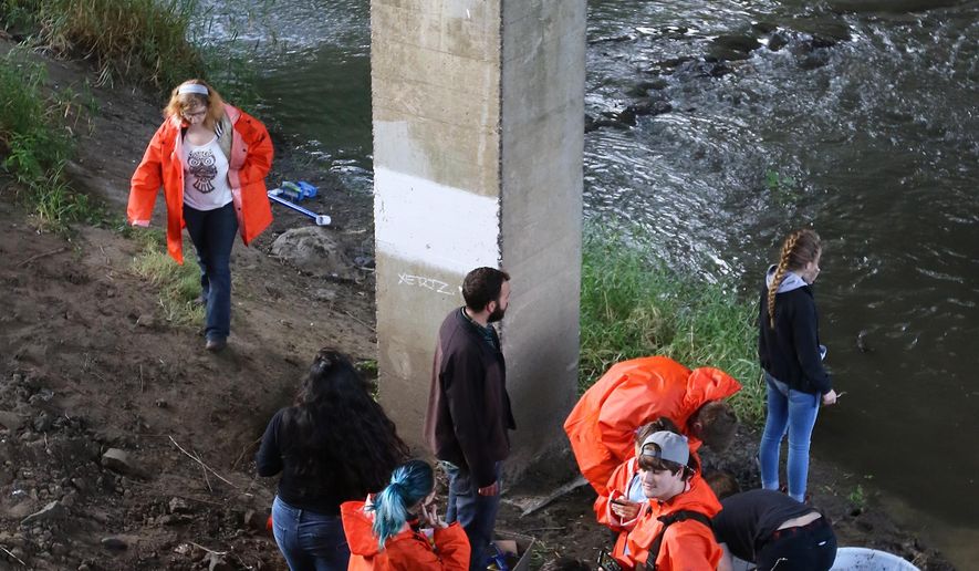 ADVANCE FOR WEEKEND EDITIONS - In this Wednesday Oct. 5, 2016, photo, Phoenix School students take measurements of the water quality of Deer Creek in Roseburg, Ore. During the past five years, Phoenix School students have worked to restore Deer Creek, removing invasive plant species and planting native species in the area through a $78,653 grant. (Michael Sullivan/The News-Review via AP)