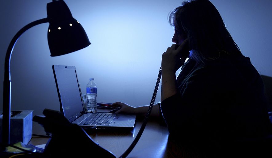 ADVANCE FOR WEEKEND EDITIONS - In this Oct. 4, 2016, photo, a Crisis intervention specialist with the Voices of Hope crisis hotline takes a call in They are available 24 hours a day to help people find the help they need during a crisis. (Rion Sanders/The Great Falls Tribune via AP)
