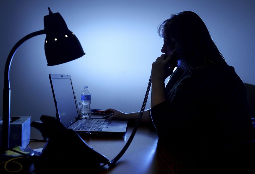ADVANCE FOR WEEKEND EDITIONS - In this Oct. 4, 2016, photo, a Crisis intervention specialist with the Voices of Hope crisis hotline takes a call in They are available 24 hours a day to help people find the help they need during a crisis. (Rion Sanders/The Great Falls Tribune via AP)