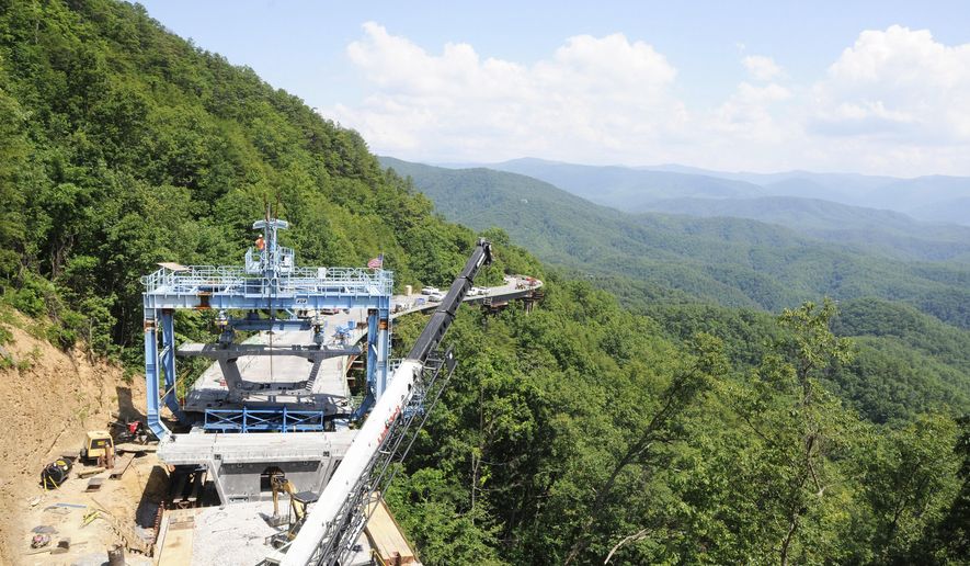 FILE - In this June 13, 2012, file photo, workers use a specialized crane to place a concrete segment onto an 800-foot bridge in an area of the unfinished Foothills Parkway near Walland, Tenn. Work is underway to complete the extension of the scenic route near the northern boundary of the Great Smoky Mountains National Park,. (Curt Habraken/The Mountain Press via AP, File).