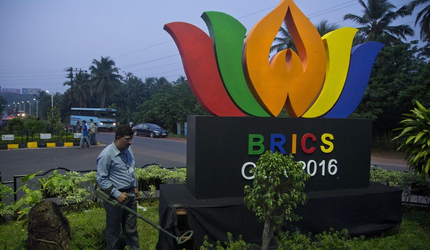 An Indian policeman from bomb squad checks a round about with a huge BRICS logo, in Goa, Friday, Oct. 14, 2016. The leaders of five big developing nations that banded together in 2009 as the so-called BRICS nations, are set to attend their annual summit Oct. 15-16, 2016 in a beach resort town in the western Indian state of Goa. But with their own economies now flagging, some analysts are questioning whether the group, consisting of Brazil, Russia, India, China and South Africa, still has clout in representing nearly half the world's population and a quarter of its economy at $16.6 trillion. (AP Photo/Anupam Nath)