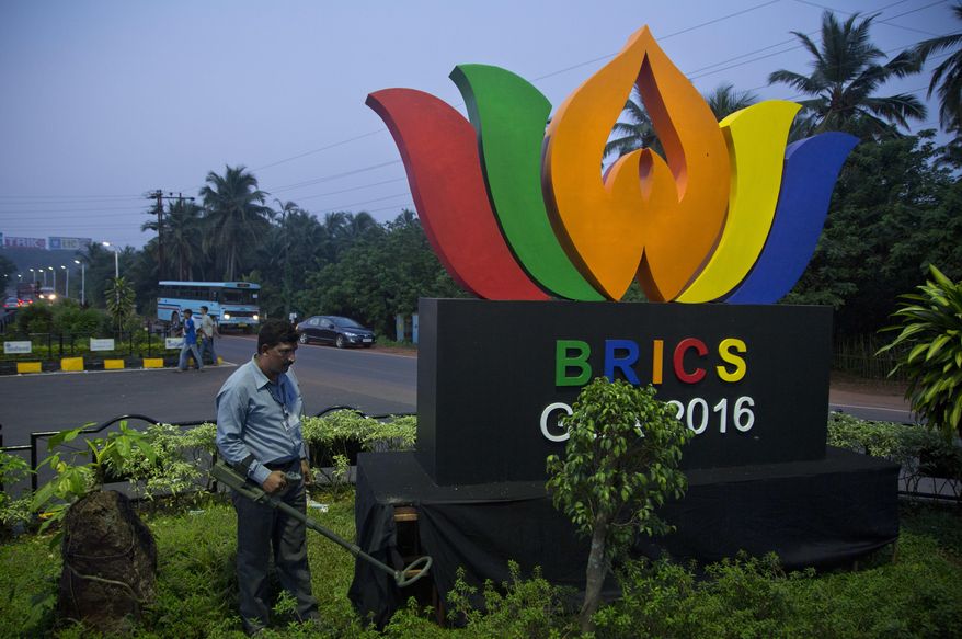 An Indian policeman from bomb squad checks a round about with a huge BRICS logo, in Goa, Friday, Oct. 14, 2016. The leaders of five big developing nations that banded together in 2009 as the so-called BRICS nations, are set to attend their annual summit Oct. 15-16, 2016 in a beach resort town in the western Indian state of Goa. But with their own economies now flagging, some analysts are questioning whether the group, consisting of Brazil, Russia, India, China and South Africa, still has clout in representing nearly half the world's population and a quarter of its economy at $16.6 trillion. (AP Photo/Anupam Nath)