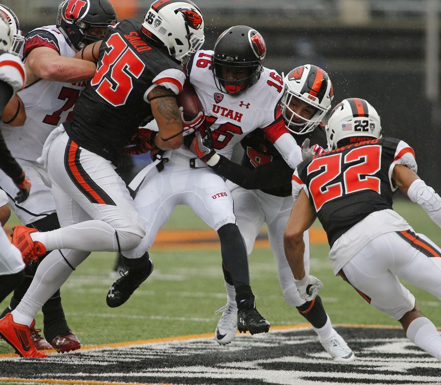 Utah's Cory Butler-Boyd (16) tries to push past Oregon State's Caleb Saulo (35) and Xavier Crawford (12) during the first half of an NCAA college football game in Corvallis, Ore., on Saturday, Oct. 15, 2016. (AP Photo/Timothy J. Gonzalez)
