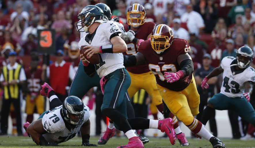 Philadelphia Eagles quarterback Carson Wentz, center, tries to outrun Washington Redskins defensive end Chris Baker (92) in the second half of an NFL football game, Sunday, Oct. 16, 2016, in Landover, Md. (AP Photo/Alex Brandon)