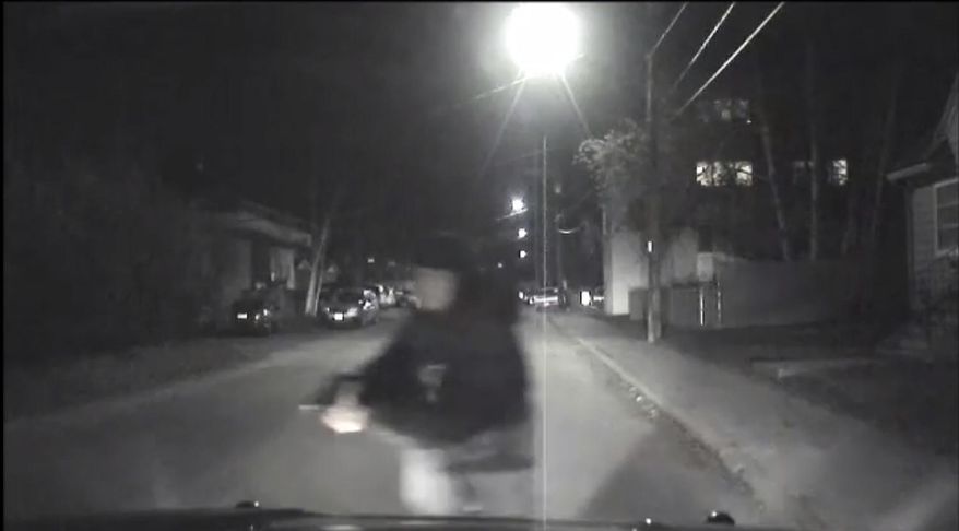 An image from video provided by the Fairbanks Police Department shows shows the suspect police believe abandoned a police car he stole after he shot an officer in Fairbanks, Ak., early Sunday, Oct. 16, 2016. An Alaska police officer was seriously injured in the early morning shooting, according to the Fairbanks police department. The Fairbanks News-Miner reports the officer was flown to Anchorage for treatment. Police are still searching for the shooter. (Fairbanks Police Department via AP)