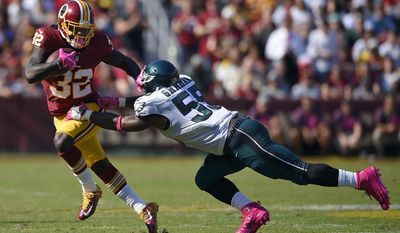 Washington Redskins running back Rob Kelley, left, pushes away Philadelphia Eagles defensive end Brandon Graham as he rushes the ball in the first half of an NFL football game, Sunday, Oct. 16, 2016, in Landover, Md. (AP Photo/Nick Wass)