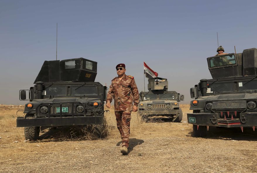 The Commander of the Joint Military Operation Commander, Army Lt. Gen. Talib Shaghati, walks in the town of Khazer, Iraq, Monday, Oct. 17, 2016. He praised the role of the U.S.-led International Coalition as "very important" through carrying out airstrikes and sharing intelligence. Citing intelligence information, he claimed some IS militants were fleeing Mosul to Syria along with their families. (AP Photo/Khalid Mohammed)