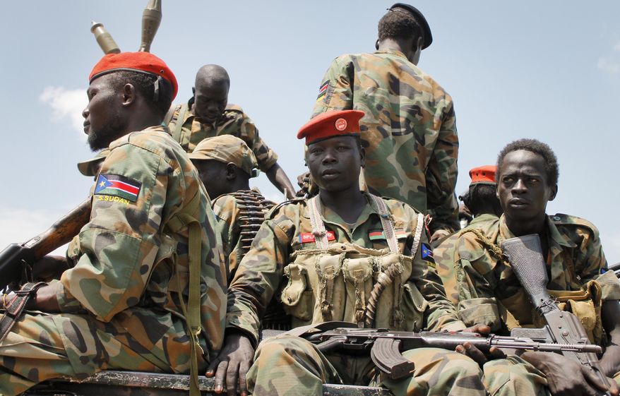 In this photo taken Sunday, Oct. 16, 2016, a group of South Sudanese government soldiers sit on the back of a pickup truck before visiting the scene of a recent battle in Malakal, South Sudan. Following clashes last week in the outskirts of the city, which has been reduced to rubble and almost entirely deserted by civilians, the army flew in journalists on Sunday to show that they retain control of the strategic city, even though rebels still vow to take it. (AP Photo/Justin Lynch)