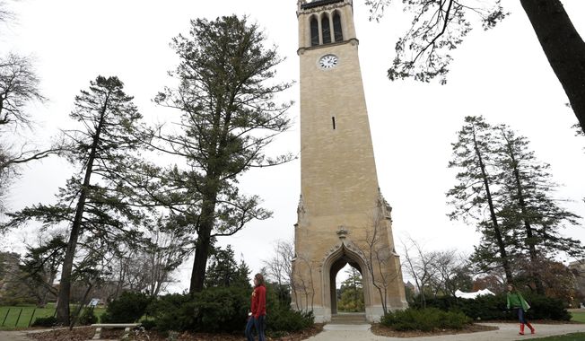 In this Oct. 25, 2012, file photo ,students walk past the Campanile on the Iowa State University campus in Ames, Iowa. (AP Photo/Charlie Neibergall, File)