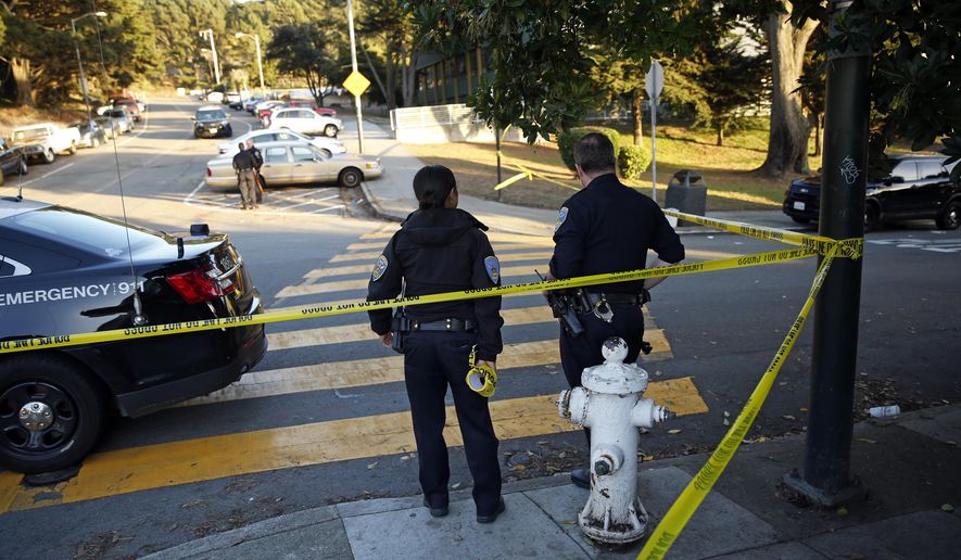 San Francisco Police stand at the site of a shooting outside the June Jordan School for Equity and City Arts and Technology High School, which share a campus, in San Francisco, Calif., Tuesday, Oct. 18, 2016. Several teenage students were shot in the shared parking lot of the two San Francisco high schools Tuesday, and one of the students is in critical condition, authorities said. (Scott Strazzante/San Francisco Chronicle via AP)