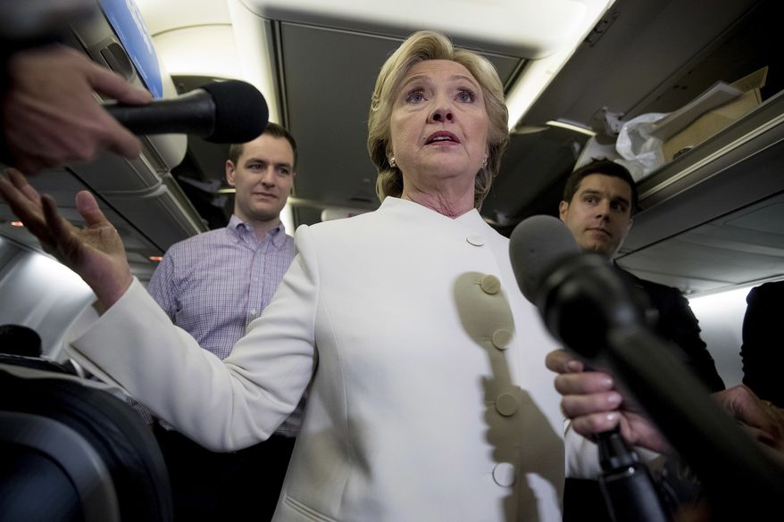 Democratic presidential candidate Hillary Clinton (center) accompanied by campaign manager Robby Mook (left) and traveling press secretary Nick Merrill (right) speaks with members of the media aboard her campaign plane at McCarran International Airport in Las Vegas, Wednesday, Oct. 19, 2016, following the third presidential debate. (AP Photo/Andrew Harnik) **FILE**