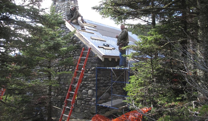 In this Wednesday, Oct. 19, 2016 photo workers rebuild an historic stone cabin on Mount Mansfield in Stowe, Vt. The building was gutted in a fire last Christmas Eve when the founder of Burton Snowboards' two sons accidentally caused a fire. The family donated $150,000 to help rebuild the Stone Hut, which will be open for overnight guests starting on Dec. 1. (AP Photo/Lisa Rathke)