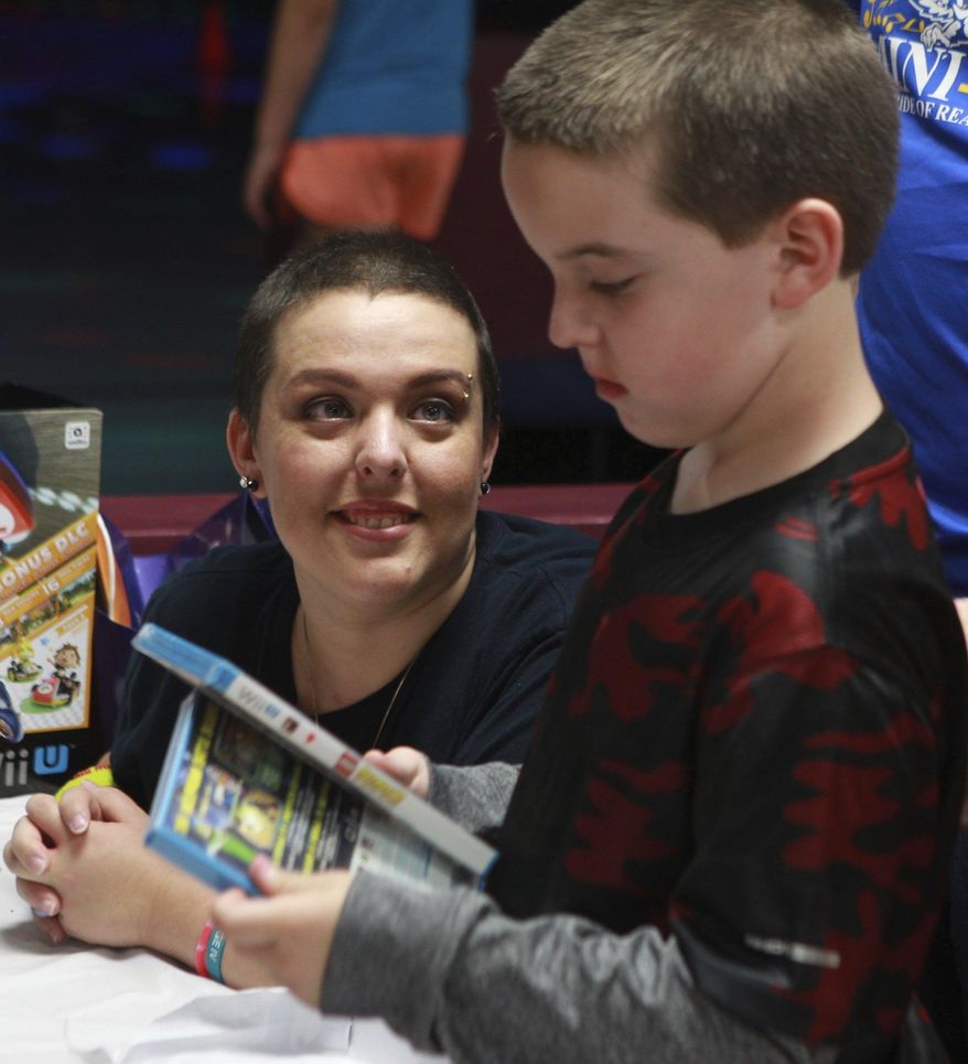 ADVANCE FOR SUNDAY OCT. 23 AND THEREAFTER - In an Oct. 3, 2015 photo, Jennifer Cooper, 34, looks at her son Devon during his 8th birthday party at Angelo Skate and Fun Center. Cooper has metastatic breast cancer and is now on in-home hospice care. Since her diagnosis, Jennifer Cooper has counted time by birthdays and holidays. (Michelle Gaitan/Standard-Times via AP)
