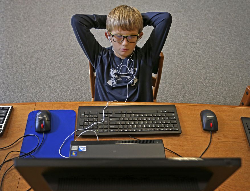 ADVANCE FOR USE SUNDAY, OCT. 23 - In this Thursday, Oct. 13, 2016 photo, fourth-grader Landon Gregory uses the Voice Dream Reader app on a desktop computer in the library at Kathryn Griffis Elementary in Caddo Mills, Texas. The text-to-speech app is a tool that helps print-disabled students listen to articles while reading books on any devices with the app installed. (Jae S. Lee/The Dallas Morning News via AP)