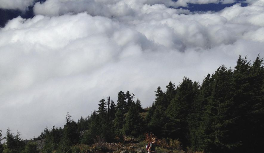 A hiker makes her final push to the top of Mailbox Peak on Oct. 2, 2016, near North Bend, Wash. A mailbox sits atop the peak and it's filled with letters and trinkets deposited by hikers. The peak also delivers stunning views that start about half a mile below the summit. (Craig Hill/The News Tribune via AP)