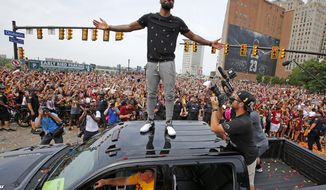 FILE - In this June 22, 2016, file photo, Cleveland Cavaliers&#39; Kyrie Irving stands on the roof of a pickup truck before a parade celebrating the NBA basketball team&#39;s championship, in downtown Cleveland. Four months after LeBron James and the Cavaliers ended the city’s championship drought at 52 years by winning the NBA title, the Indians are back in the World Series for the first time since 1997.  ( (AP Photo/Gene J. Puskar, File)