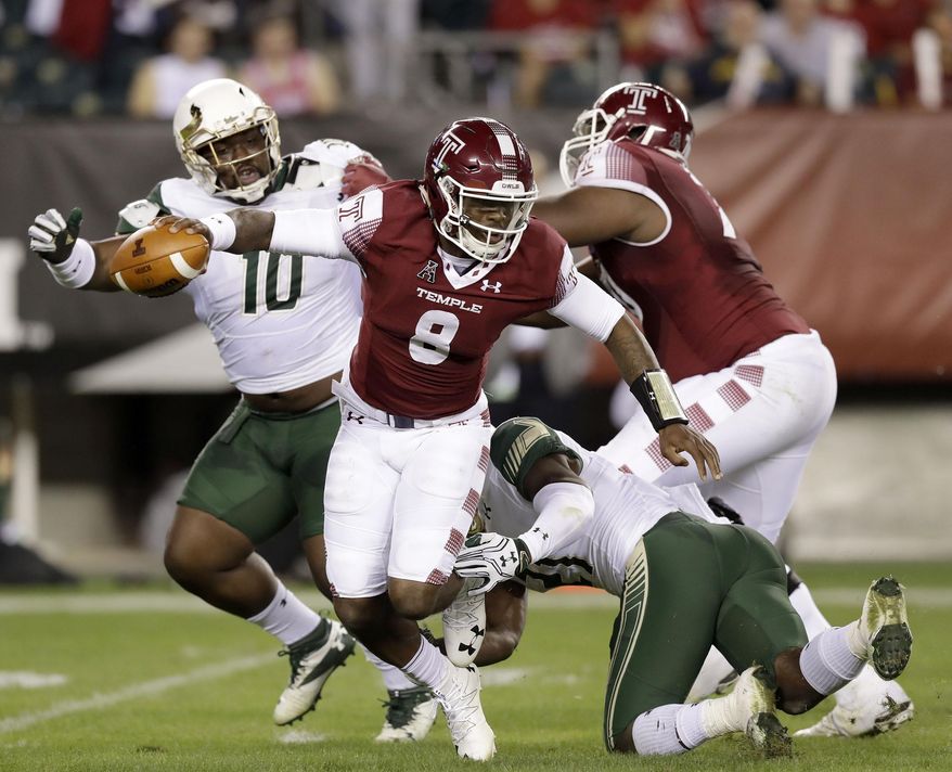 Temple quarterback Phillip Walker escapea from South Florida's Khalid McGee as Deadrin Senat, left, gets blocked by Temple offensive lineman Jovahn Fair during the first quarter of an NCAA college football game Friday, Oct. 21, 2016, in Philadelphia. (Yong Kim/The Philadelphia Inquirer via AP)