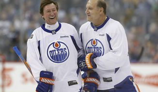Former Edmonton Oilers hockey players Wayne Gretzky, left, and Dave Semenko joke around during a practice for the NHL&#39;s Heritage Classic Alumni game in Winnipeg, Manitoba, Friday, Oct. 21, 2016. (John Woods/The Canadian Press via AP)
