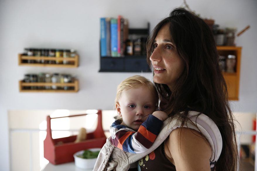 In this Oct. 20, 2016 photo, vegan mother Fulvia Serra carries her 1-year-old baby, Sebastiano, at home in Fort Collins, Colo. Serra, originally from Italy, and her husband, Scott, are raising their son vegan. Despite criticism and innuendo from some circles, pediatricians and nutritionists agree it's perfectly healthy to feed babies a vegan diet. However, parents need to be well-informed about the nutritional elements different foods offer, and work closely with their doctor or health care provider. (AP Photo/Brennan Linsley)