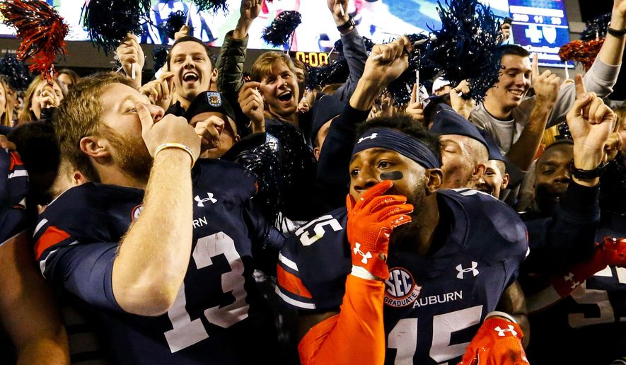 Auburn quarterback Sean White (13) and defensive back Joshua Holsey (15) celebrate after they defeated Arkansas 56-3 in an NCAA college football game, Saturday, Oct. 22, 2016, in Auburn, Ala. (AP Photo/Butch Dill) ** FILE **