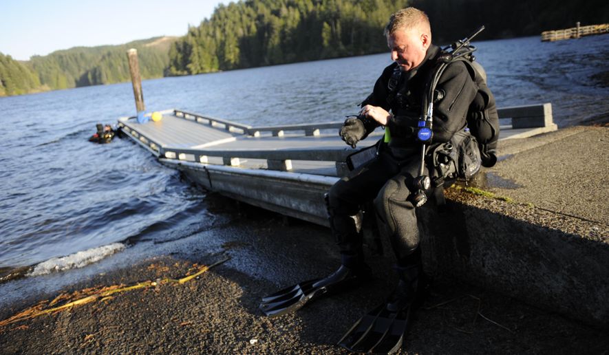 ADVANCE FOR THE WEEKEND OF OCT. 22-23 AND THEREAFTER - In a Sept. 28, 2016 photo, Bandon Dive Team dive chief Bob Hood removes his gloves after exiting the water at Eel Lake during a training session in William M. Tugman State Park near Lakeside, Ore. In 1994, he and a few other divers formed an unofficial team because they had all done commercial diving in the past and wanted to put their skills to good use. (Amanda Loman/The World via AP)