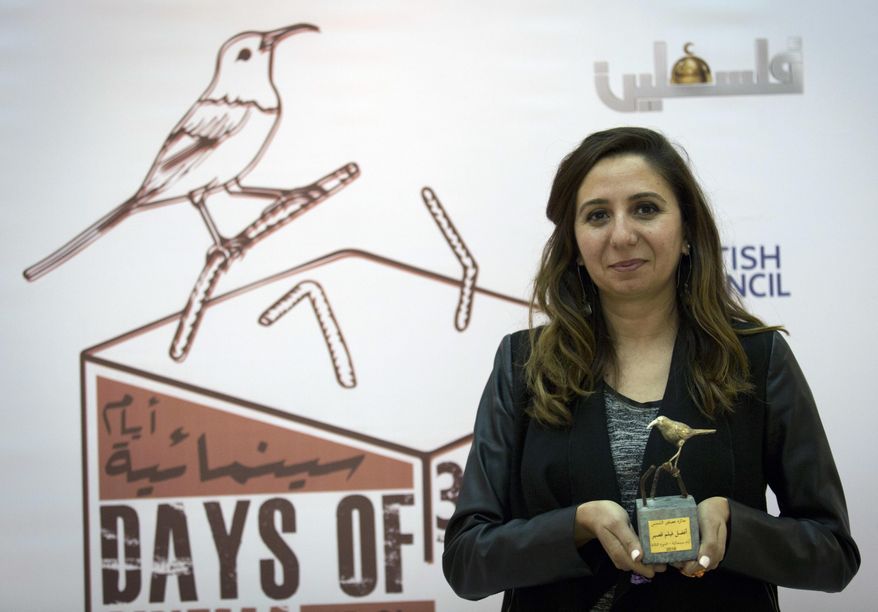 In this Thursday Oct. 20, 2016 photo, Palestinian producer May Odeh, holds the Sunbird Short Film Award trophy for the film entitled “Izriqaq (Blued),” during the Days Of Cinema awards ceremony, in the West Bank city of Ramallah. Filmlab, a Palestinian nonprofit backed by European partners, has launched a new cinema prize in an attempt to encourage the local filmmaking industry and cinema culture in the Palestinian territories. The film organization hopes the “Sunbird Prize” will become the Palestinian version of the Oscars. (AP Photo/Nasser Nasser)