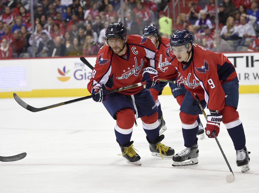 Washington Capitals left wing Alex Ovechkin (8) and defenseman Dmitry Orlov (9), both of Russia, look on during the first period of an NHL hockey game against New York Rangers, Saturday, Oct. 22, 2016, in Washington. (AP Photo/Nick Wass)