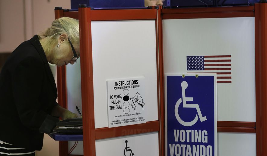 Voter Marla Pyle, of Worcester, Mass., left, fills out a ballot at an early voting location, Monday, Oct. 24, 2016, in Worcester, Mass. For the first time in Massachusetts, voters can cast their ballots for president before Election Day. Early voting begins Monday and will continue through Nov. 4. (AP Photo/Steven Senne)