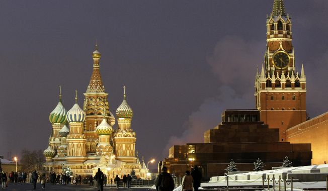 In this Dec. 10, 2009, file photo, people walk in Red Square, with St. Basil Cathedral, left, the Kremlin&#x27;s Spassky Tower, right back, and Lenin Mausoleum, right, in Moscow, Russia. (AP Photo/Misha Japaridze, File)