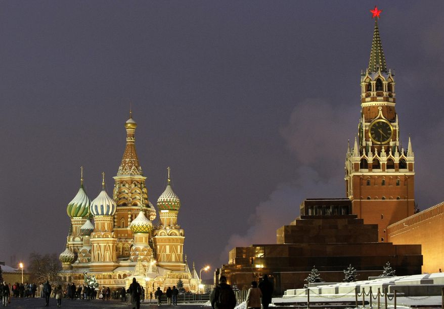 In this Dec. 10, 2009, file photo, people walk in Red Square, with St. Basil Cathedral, left, the Kremlin&#39;s Spassky Tower, right back, and Lenin Mausoleum, right, in Moscow, Russia. (AP Photo/Misha Japaridze, File)