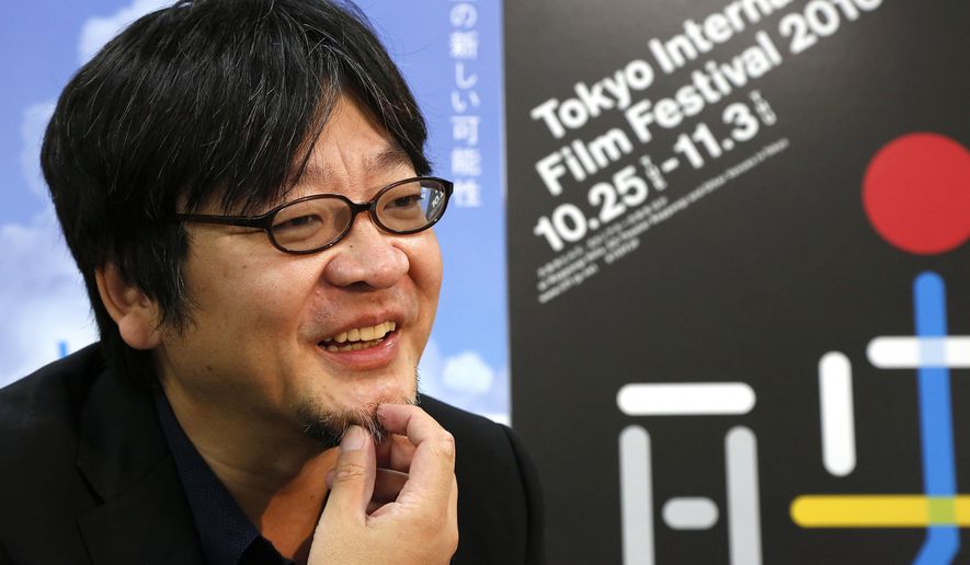 In this Friday, Sept. 30, 2016 photo, Japanese animation director Mamoru Hosoda smiles during an interview with The Associated Press at his Chizu Studio in suburban Tokyo. Time warps, half-bestial children and parallel worlds are, for Hosoda, a natural way to pursue the universal coming-of-age story that has driven all his movies. A retrospective of his works, from his early shorts to his latest “The Boy and the Beast,” is highlighted at the upcoming Tokyo International Film Festival. (AP Photo/Koji Ueda)