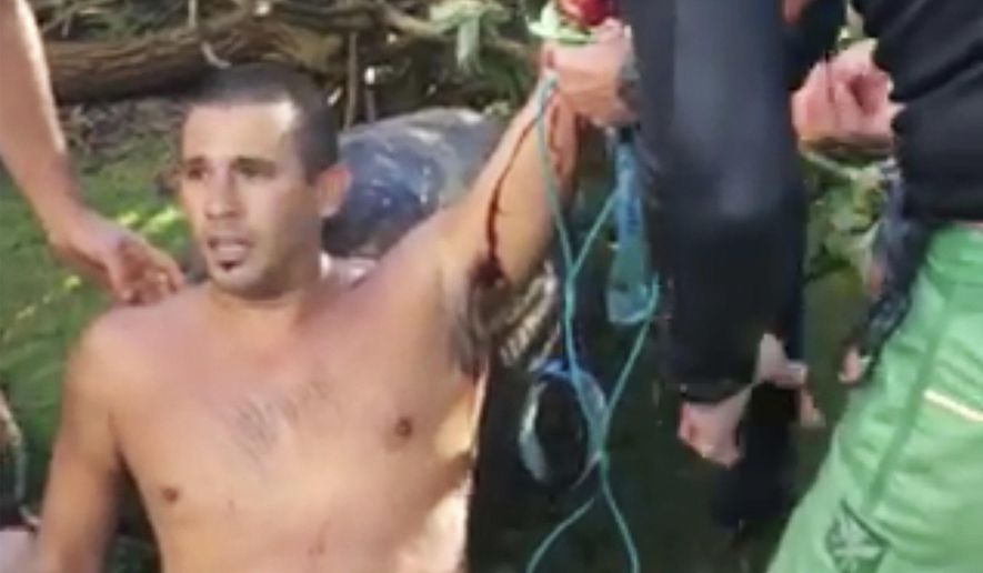 In this Friday, Oct. 21, 2016 image taken from video provided by Matt Meola, surfer Federico Jaime, center, is helped after being bitten by a shark near Paia, Hawaii, on the island of Maui. Jamie is recovering from the shark bite and is making plans to reschedule his honeymoon. Jaime was surfing Friday at a beach about two blocks from his Paia home when he felt a shark chomp down on his left arm, he recalled Monday, Oct. 24, from his room at Maui Memorial Medical Center. (Matt Meola via AP)
